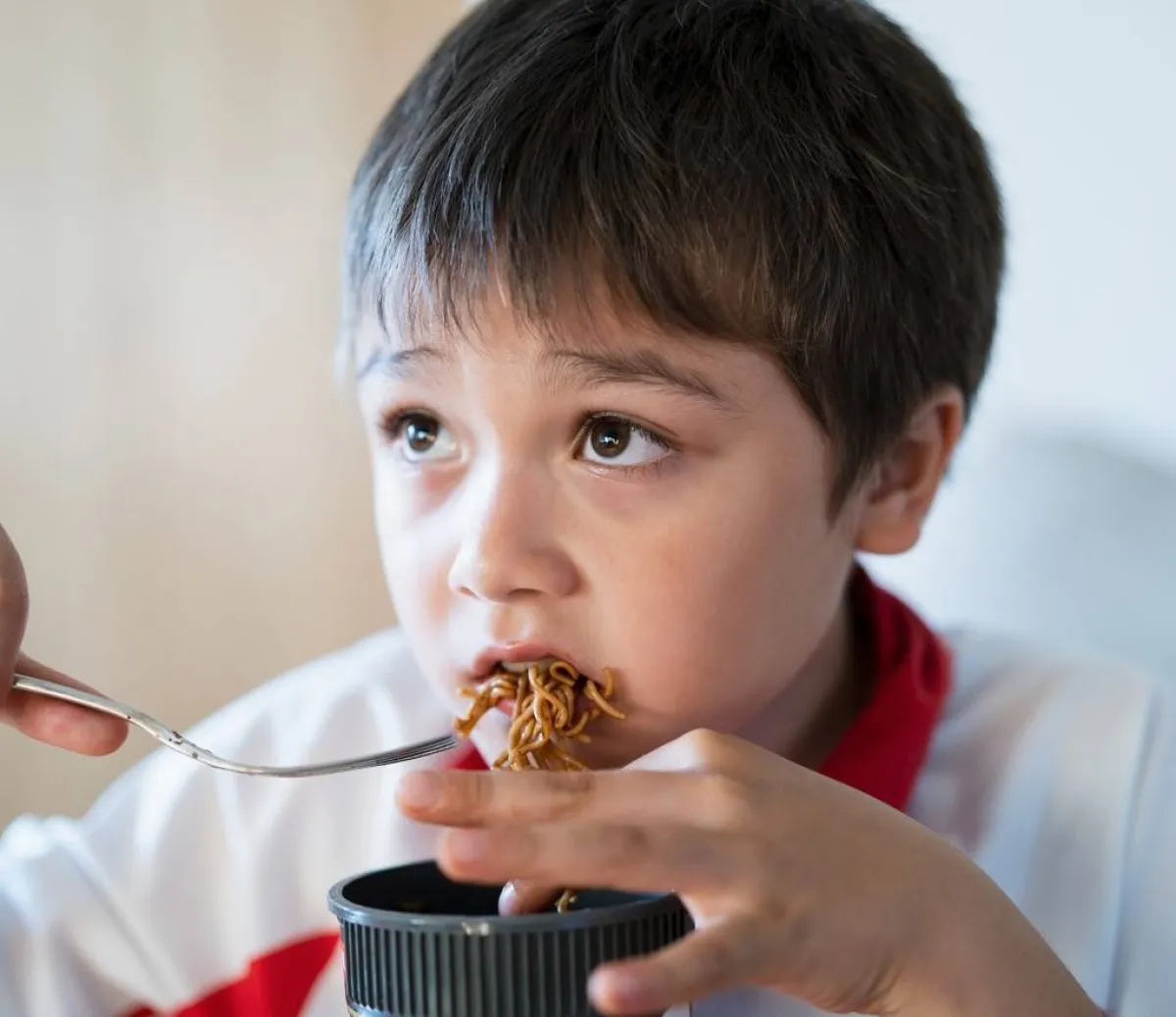 طفل يأكل النودلز بصوص الصويا