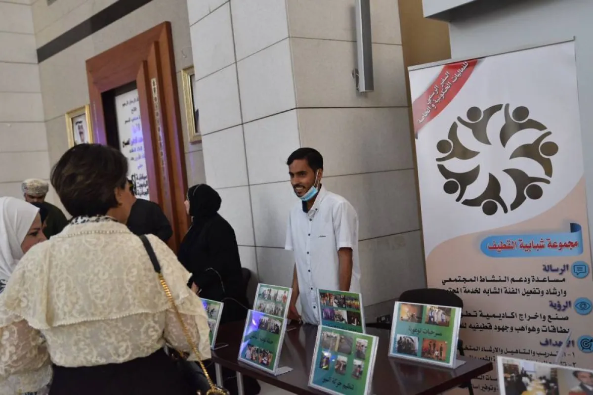 الرسام علي المفتاح خلال حديثه مع احد الزائرين