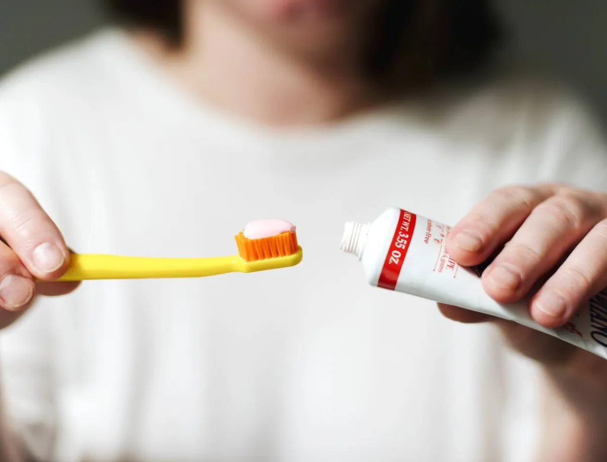 صورة لامرأة تستخدم معجون الأسنان