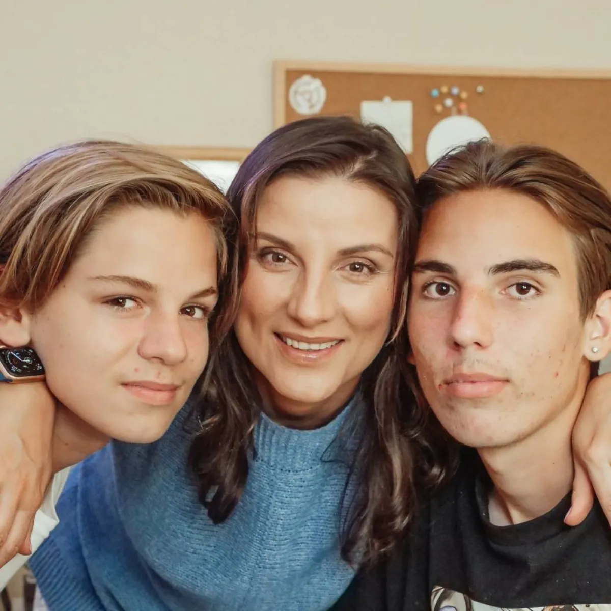 صورة لأم تحتضن ولديها المراهقين