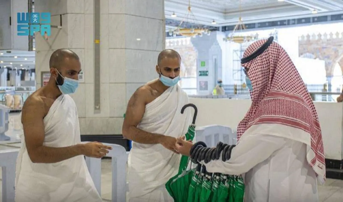 توزيع المظلات على المعتمرين - الصورة من واس