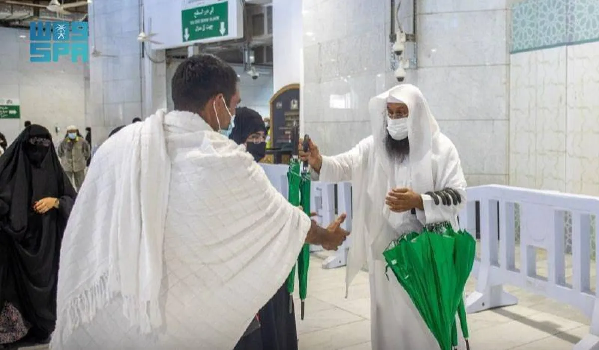 توزيع مظلات على المعتمرين - الصورة من واس