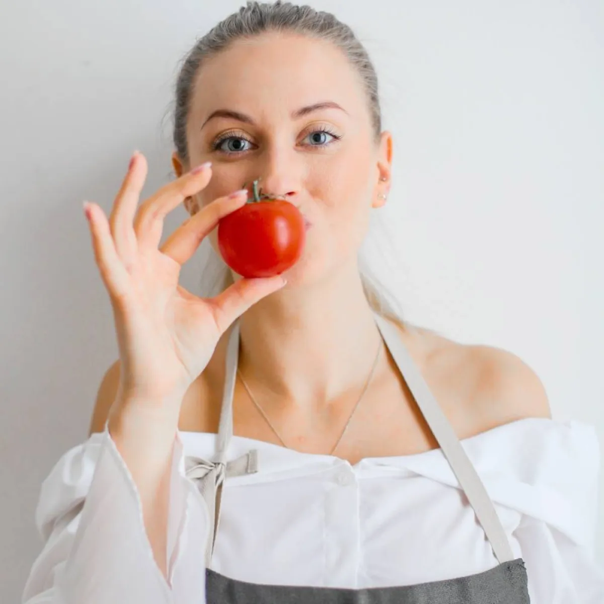 صورة لحامل تمسك بحبة طماطم