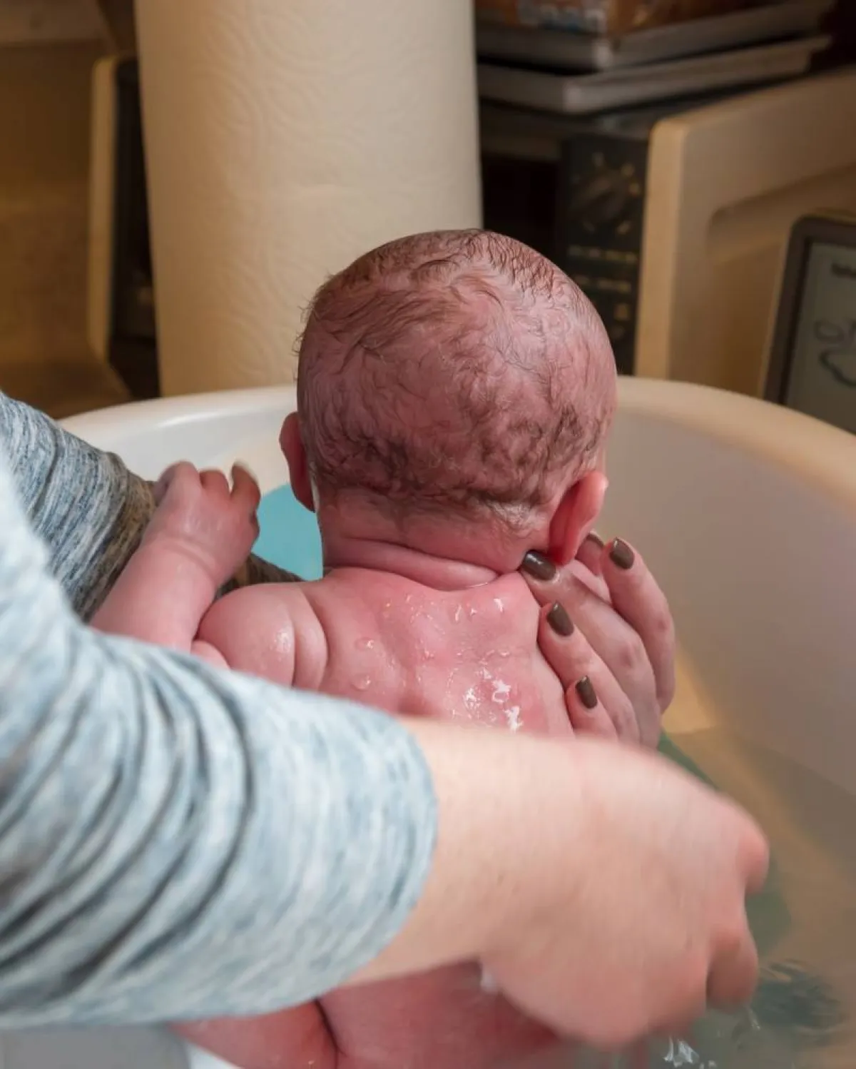 صورة لأم تحمم مولودها