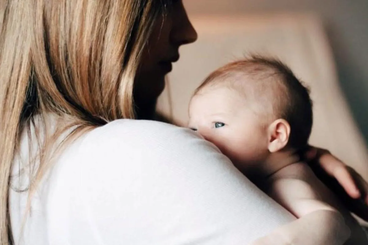 صورة أم تعني بمولودها بعد الولادة