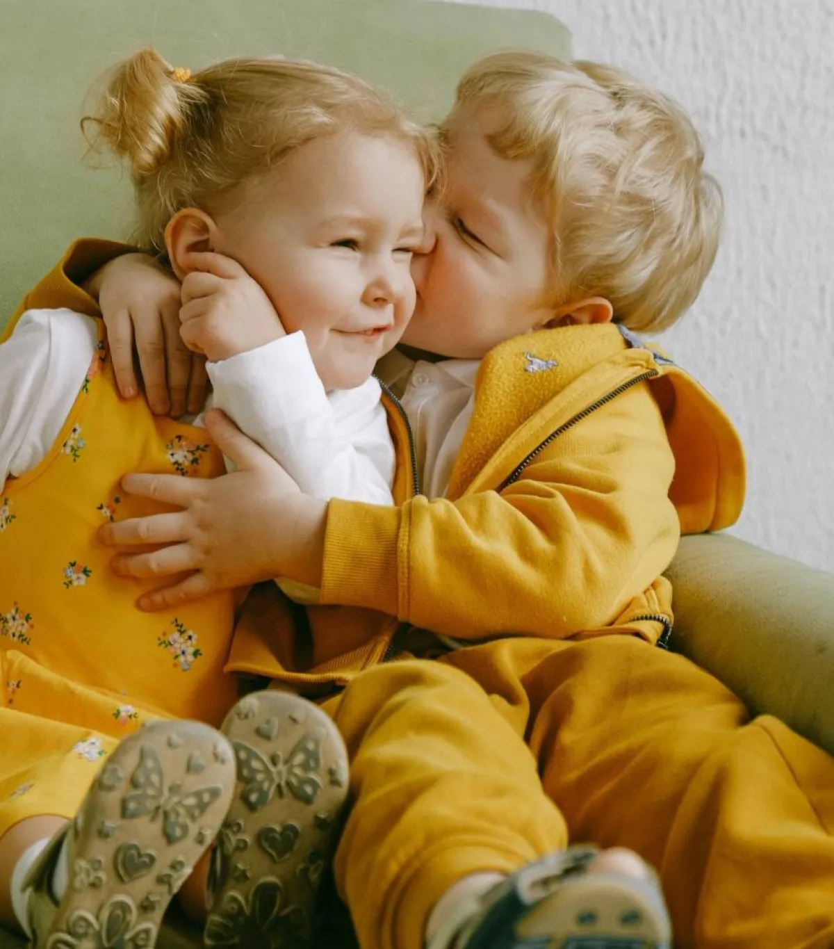 صورة لطفلين توأم يقبلان بعضهما