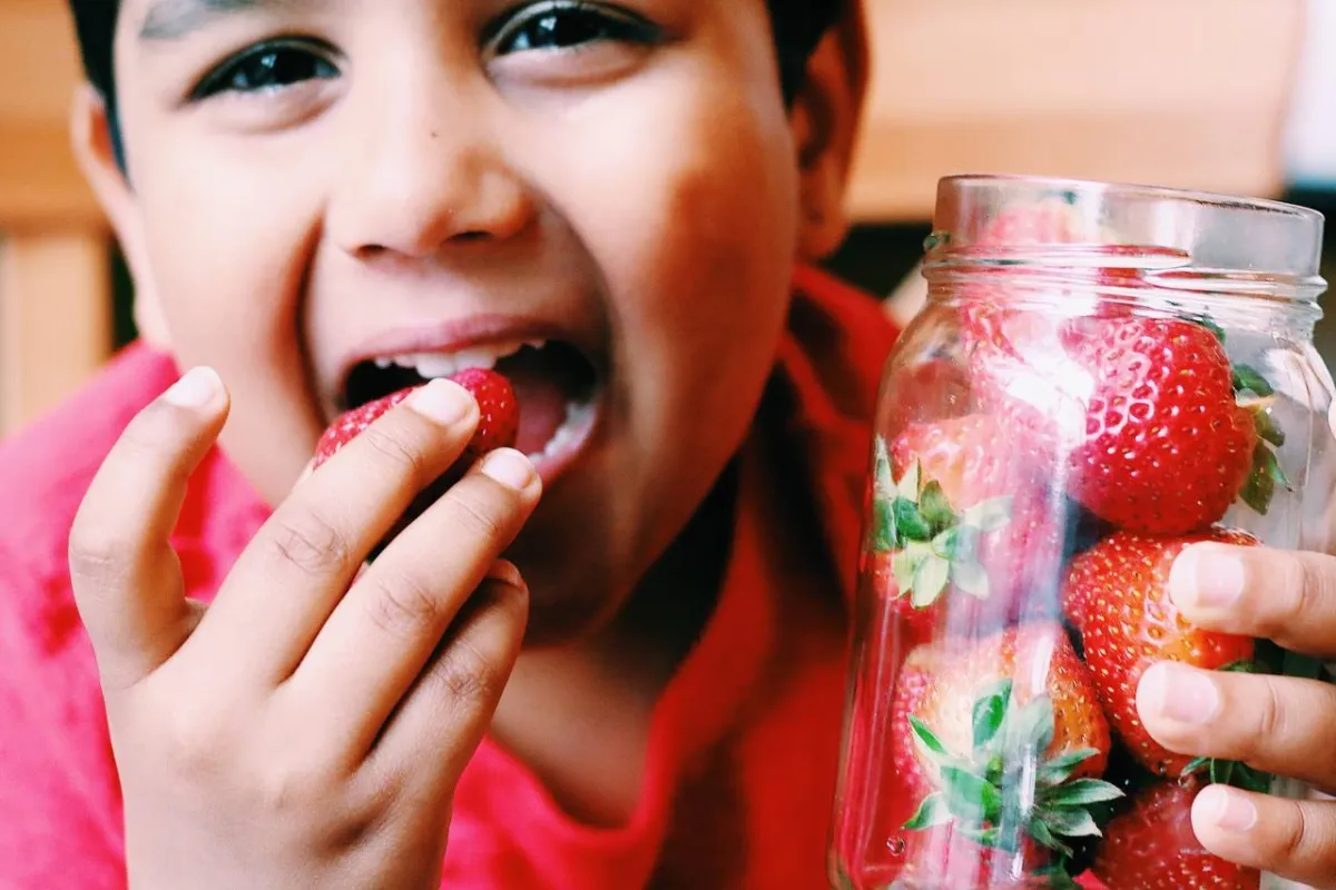 صورة لطفل يأكل الفريز