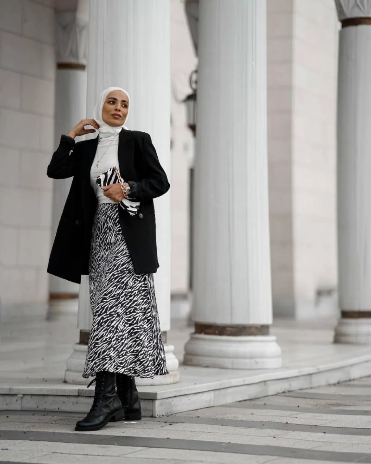  سمر شاكر بتنورة طويلة مطبعة باللونين الأبيض والأسود مع معطف قصير أسود وجزمة بوت جلد