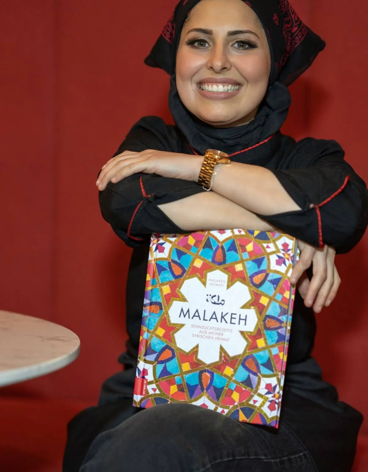 صورة ملكة جزماتي مع كتابها