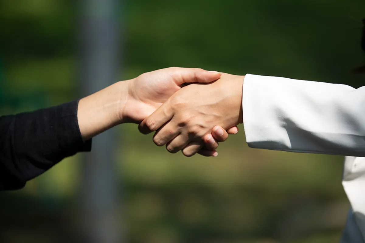 صورة تظهر شخصان يصافحان بعضهم الآخر
