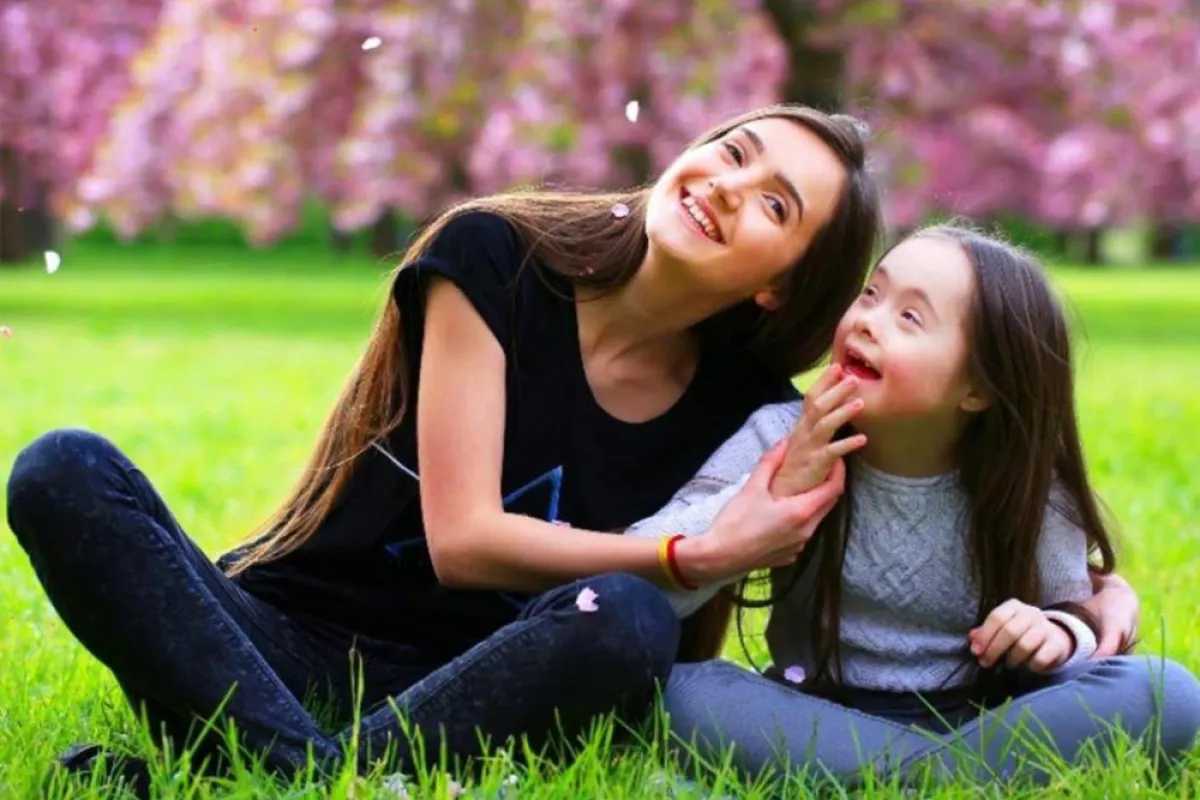 صورة لأم تشجع طفلتها من ذوي الاحتياجات الخاصة