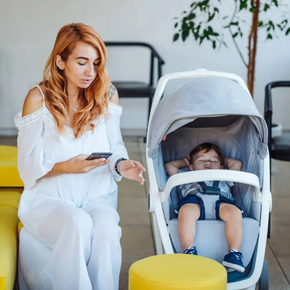 صورة لأم تجلس بجانب عربة طفلها