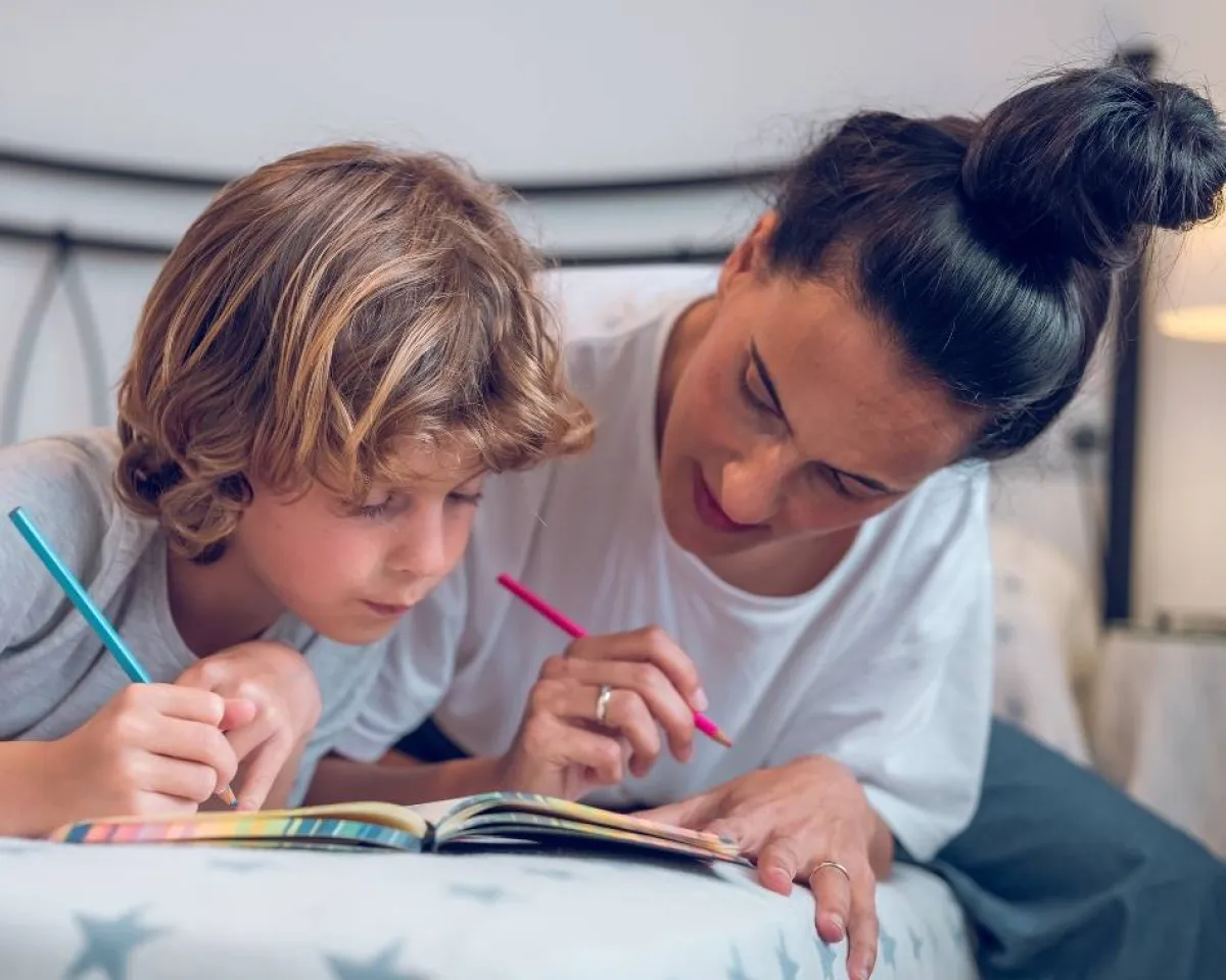 صورة لأم تساعد طفلها في موهبة الكتابة