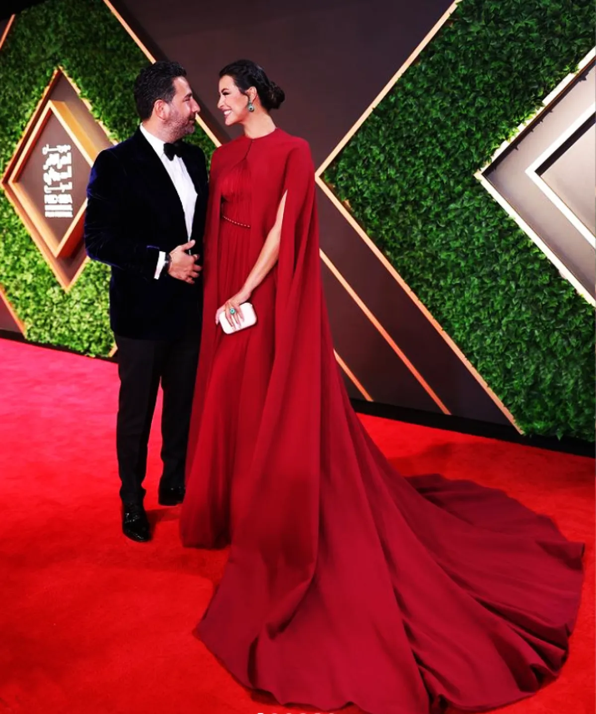 ريم السعيدي ترتدي فستاناً أحمر مع كاب عند الأكتاف