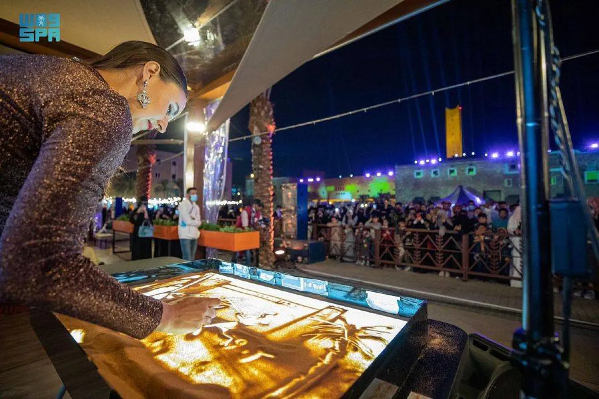 الرسامة يوريا أثناء رسم إحدى لوحاتها بمنطقة نبض الرياض - الصورة من واس