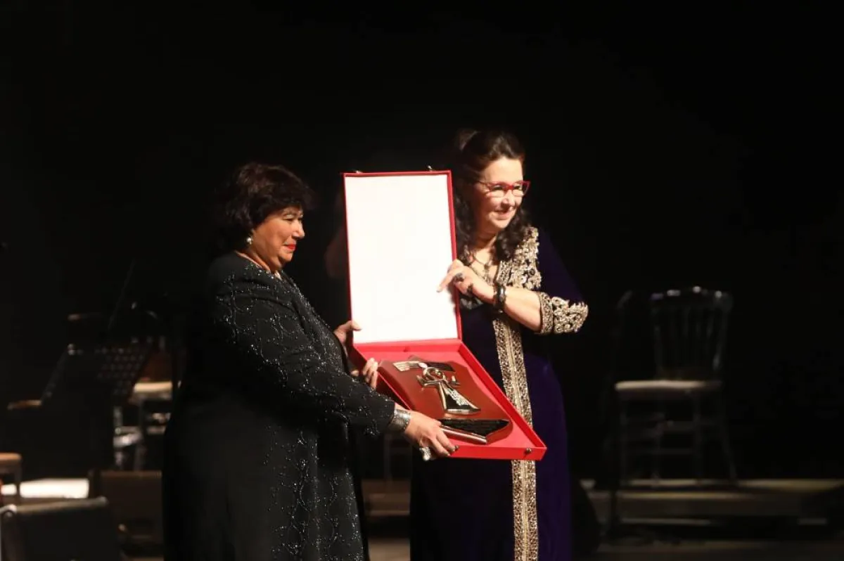 وزيرة الثقافة التونسية حياة قطاط القرْمازي تسلم درع المهرجان لوزيرة الثقافة المصرية إيناس عبد الدّايم الصورة من موقع وزارة الثقافة التونسية على الفيسبوك