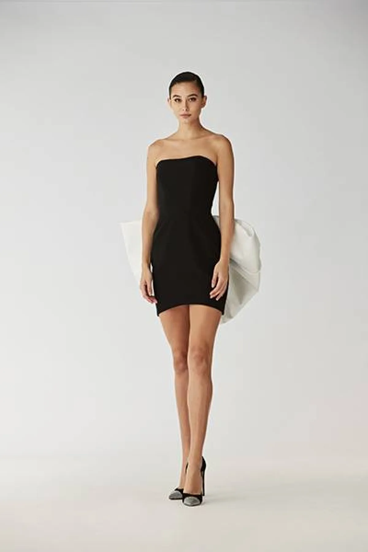 فستان اسود مع عقدة كبيرة بيضاء  من الوراء 