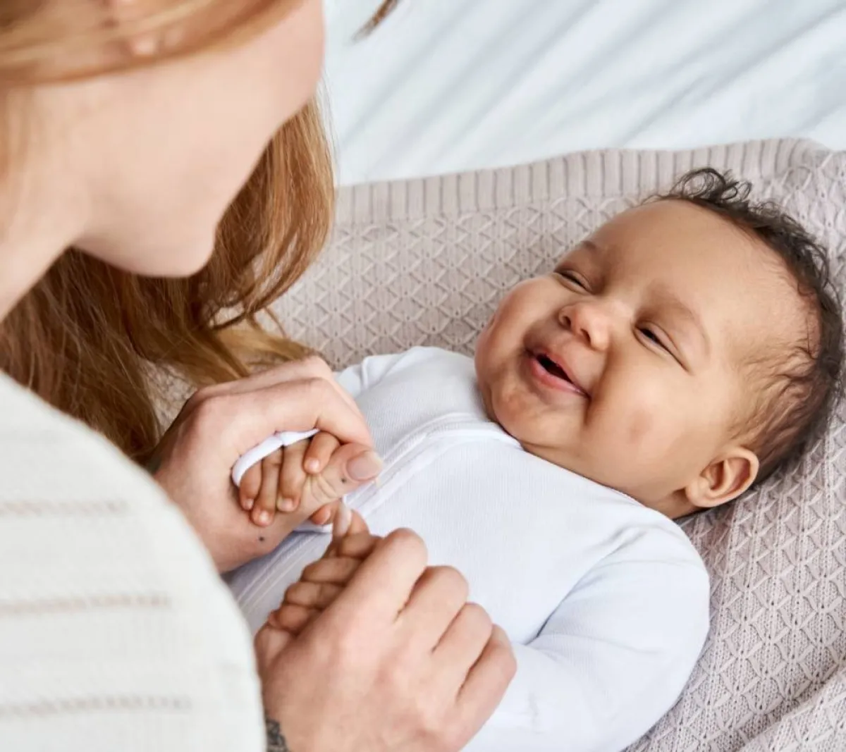 صورة أم تبتسم في وجه رضيعها