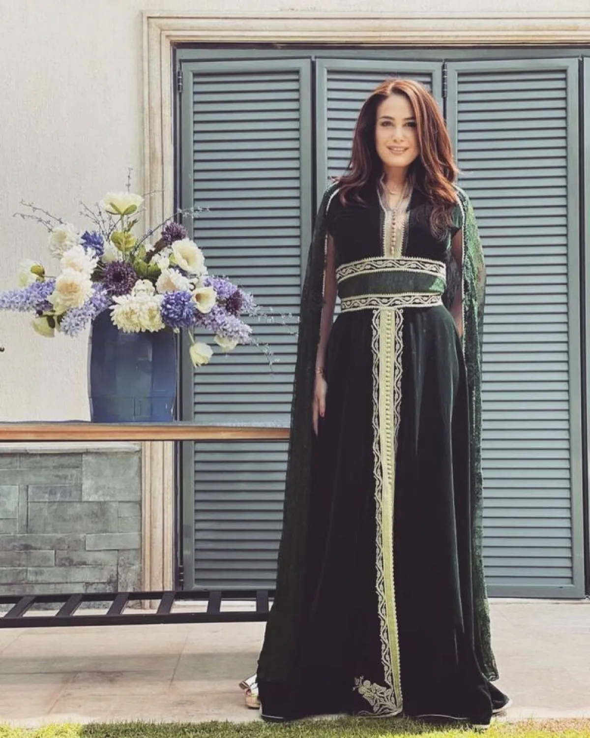 هند صبري بقفطان من القماش المخمل الأخضر الداكن بتوب مُصمم بكب طويل 