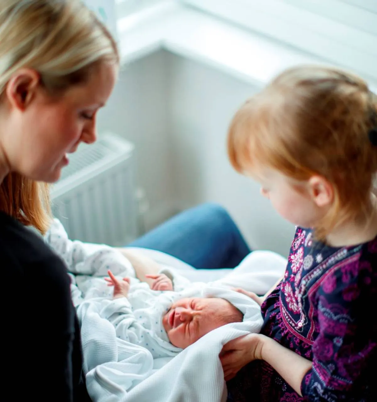 صورة لطفلة تستقبل المولود الجديد بمشاعر غير معروفة