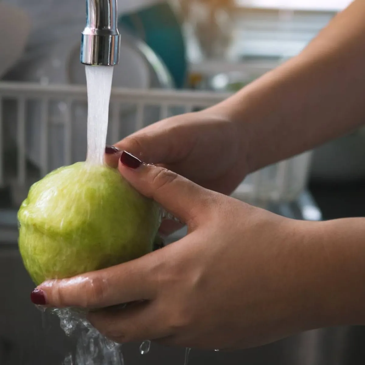 صورة لأمرأة تغسل الفاكهة