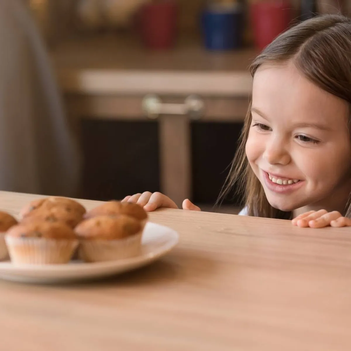 صورة لطفلة تتطلع لطبق الحلويات