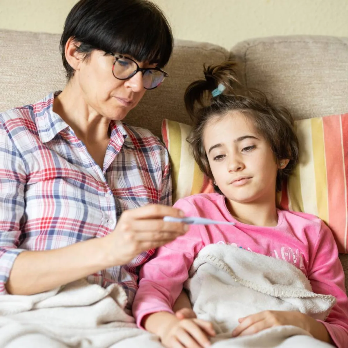 صورة لأم تقيس درجة الحرارة