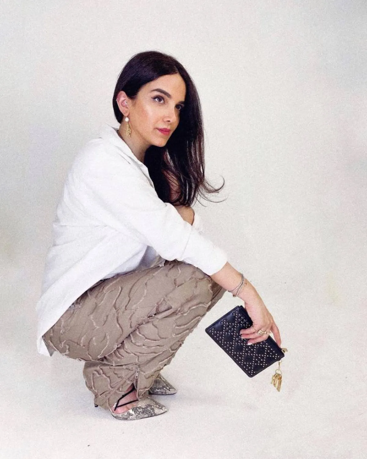 زهراء خليل بحقيبة سهرة من الجلد الأسود مطرزة بالكريستال الذهبي الصغير