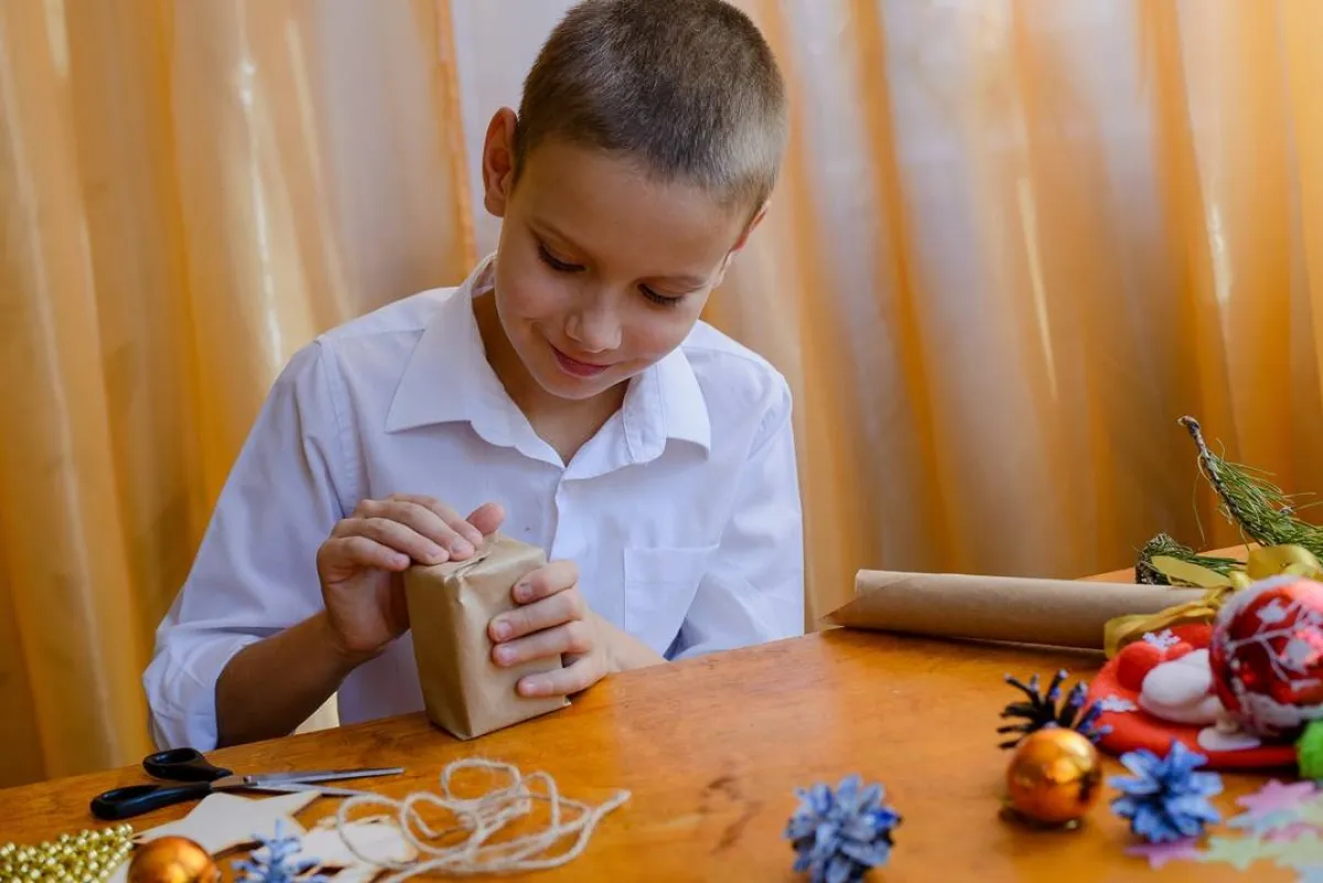 صورة لطفل يعد هدية ويغلفها للعام الجديد