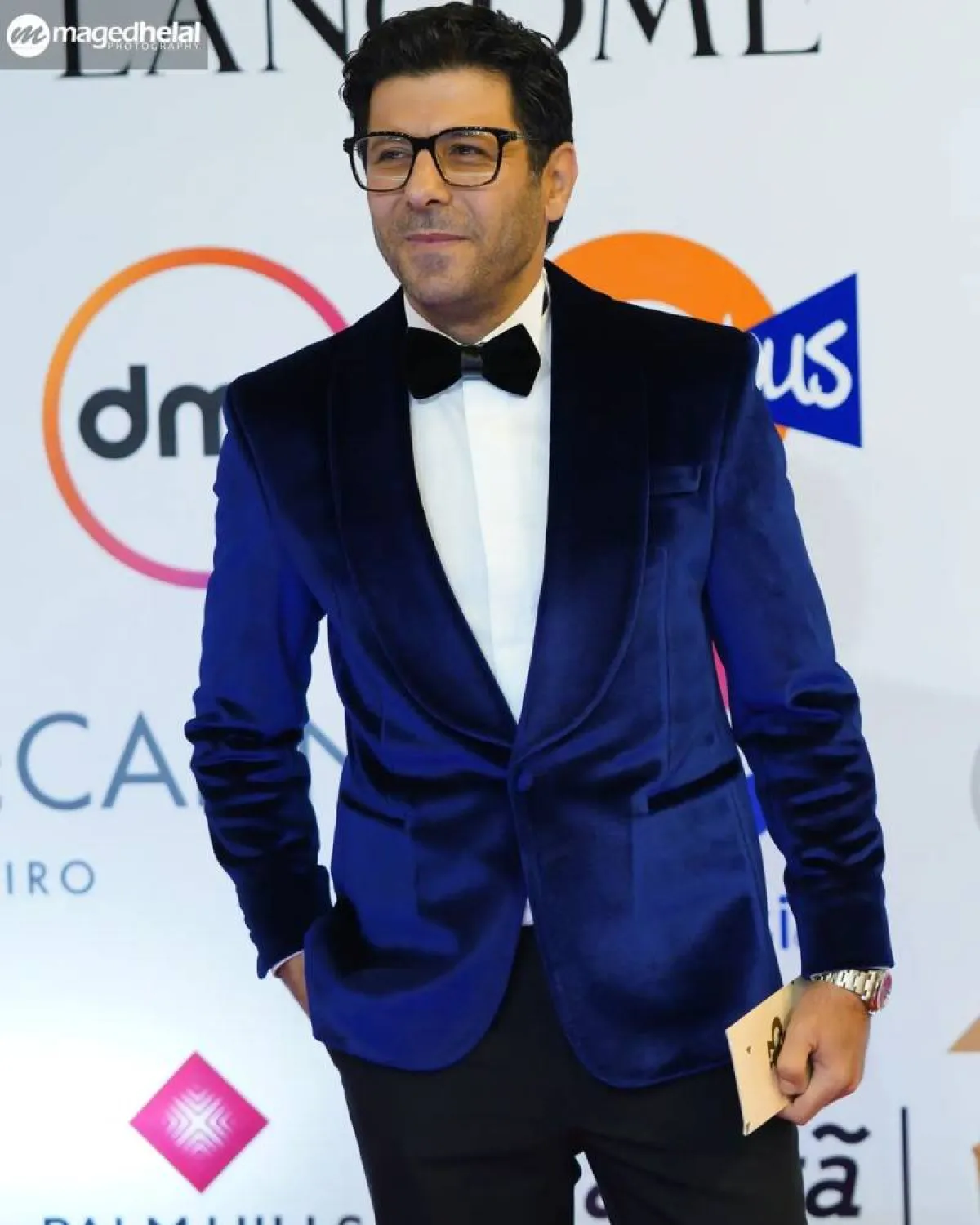 إياد نصار ببليزر من المخمل الأزرق مع قميص أبيض وبابيون عريض 