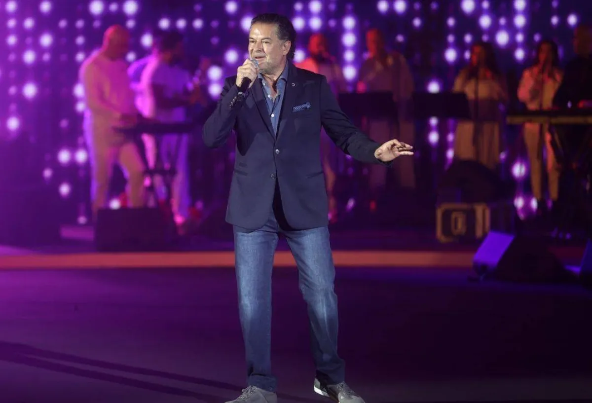 راغب علامة ببليزر أزرق داكن مع بنطلون جينز وقميص أزرق فاتح وحذاء رياضي رمادي