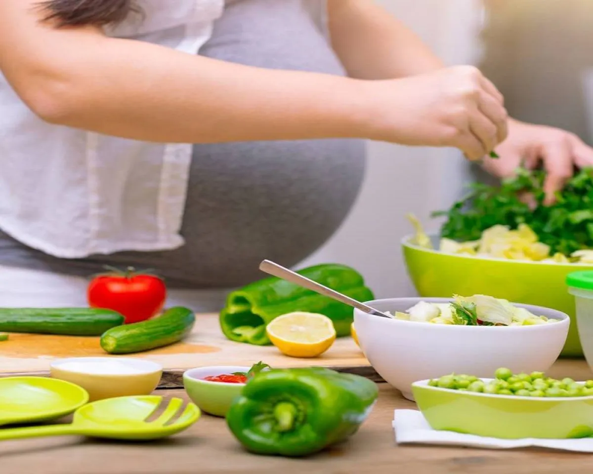 صورة لحامل تقوم بإعداد الطعام