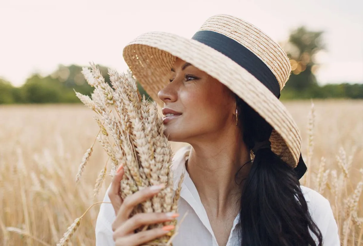 صورة لأمرأة تمسك بعشبة قمح