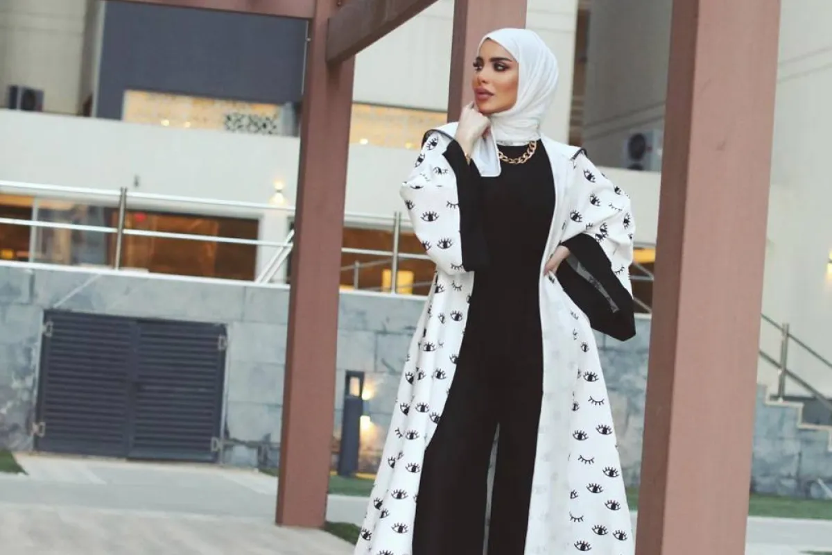 زهراء أشكناني بعباية بأكمام عريضة باللونين الأبيض والأسود مطبعة بالرسوم 