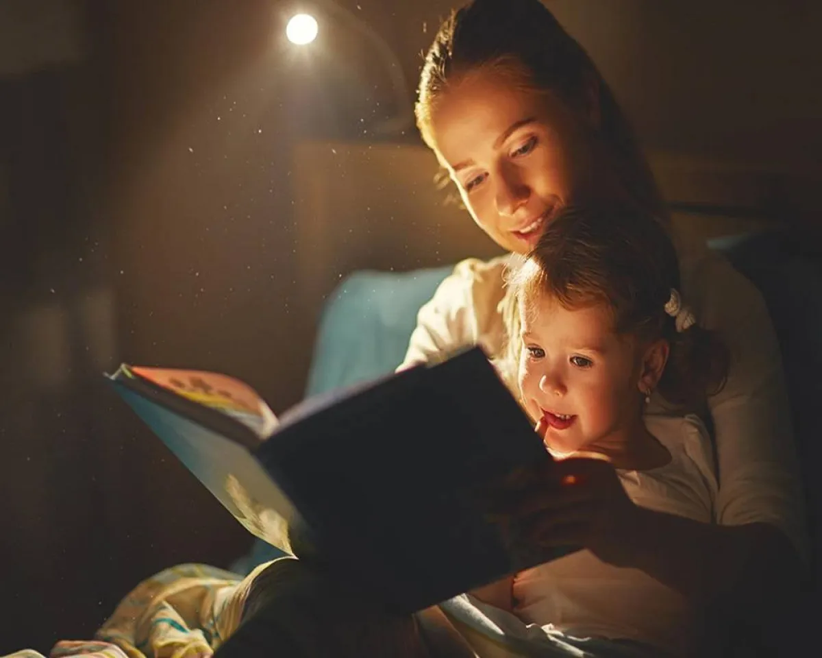 صورة لأم تقرأ قصة لطفلتها
