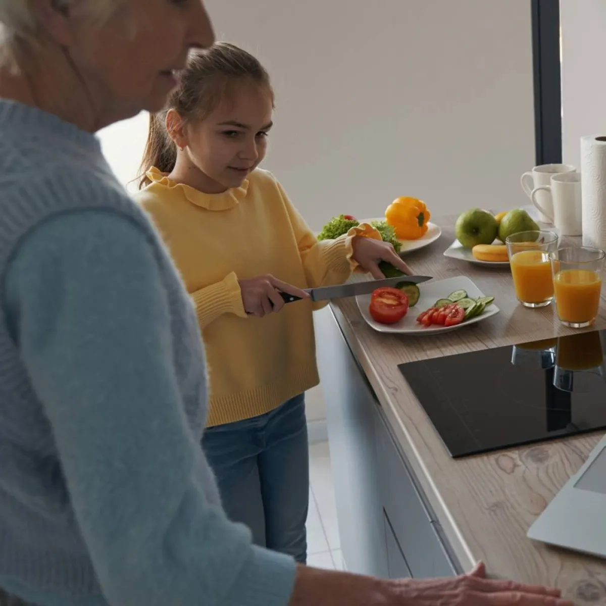 صورة لطفلة تقف بجوار أمها والموقد