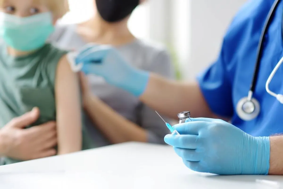 صورة لطفل يحصل على حقنة في أعلى الكتف