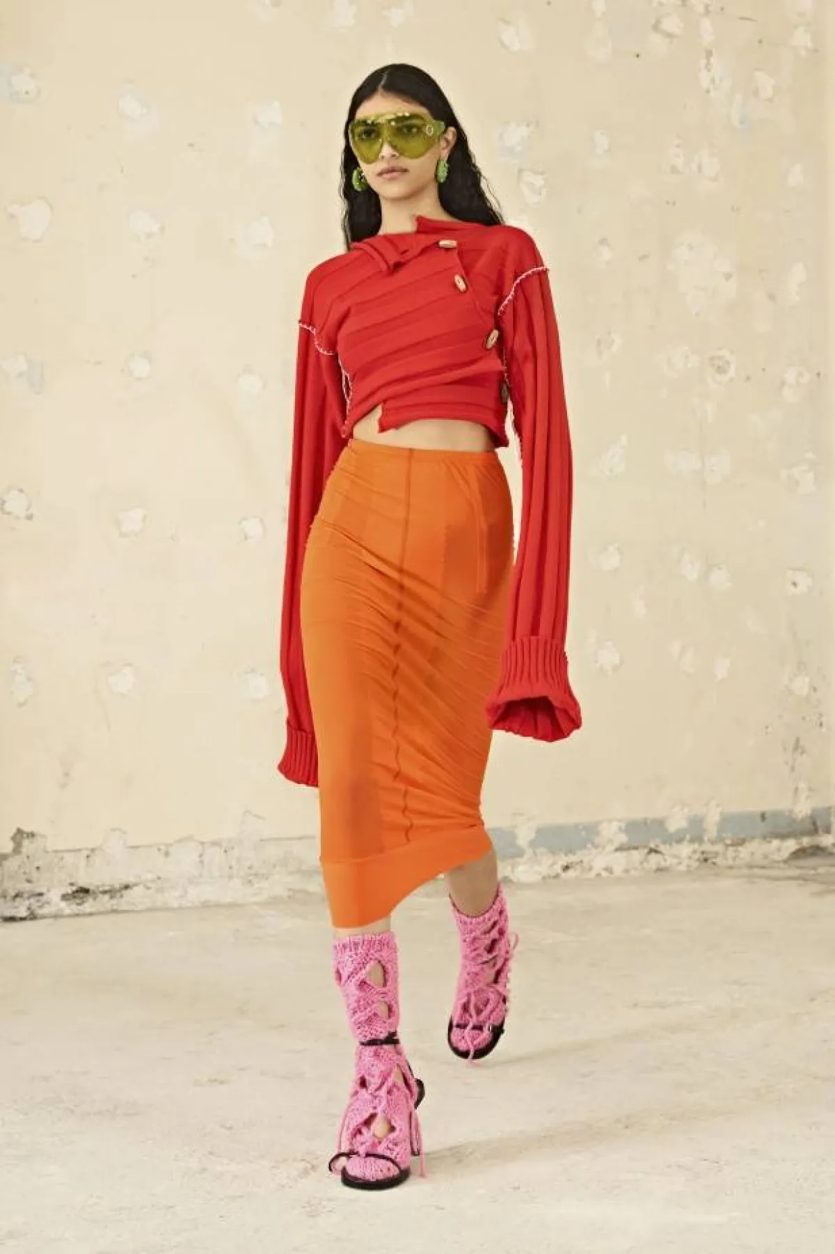 تنورة برتقالية وبلوزة حمراء وجوارب زهرية