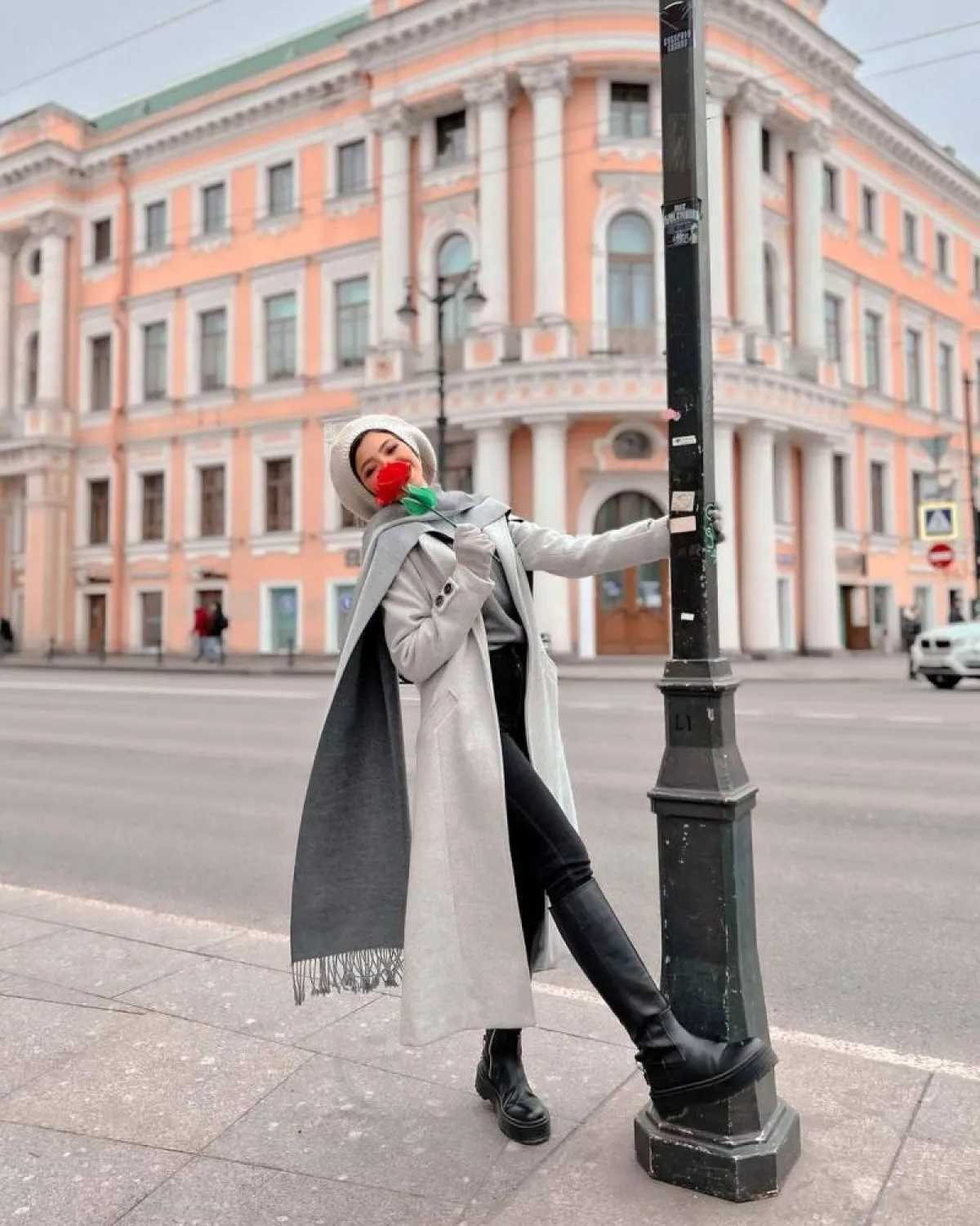 منة السني بسكارف طويل مع معطف طويل وجزمة بوت سوداء من الجلد