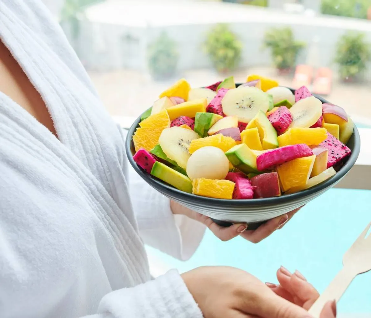 صورة لامرأة تتناول طبقاً من الفاكهة