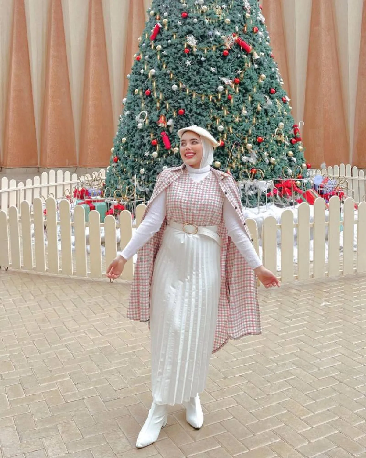 مي محمد بتنورة بليسيه بيضاء وقميص كاروهات طويل وقبعة وردي باستيل