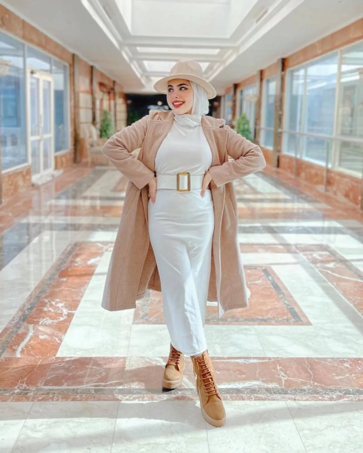 مي محمد بمعطف بيج باستيل بتصميم ميدي مع قبعة بيج وجزمة بوت جملي