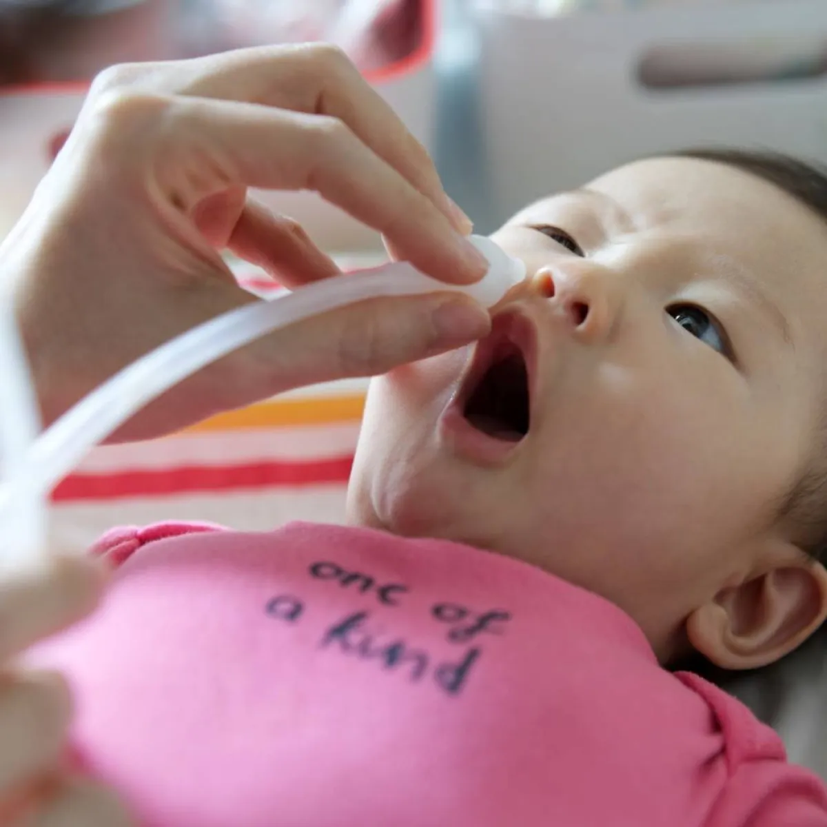 صورة لأم تنظف أنف طفلها