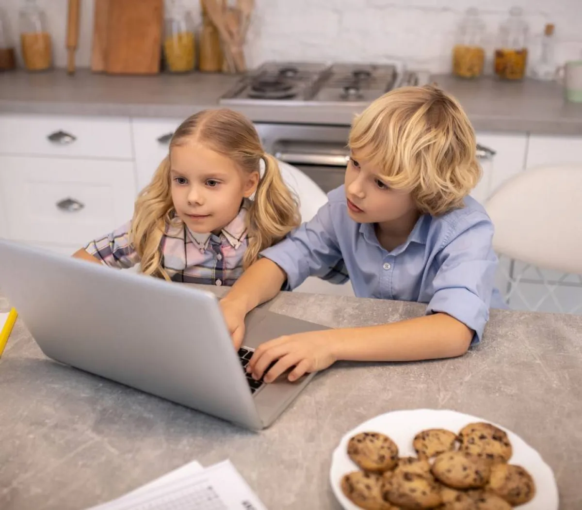 صورة لطفلين منغمسين بمراقبة الإنترنت