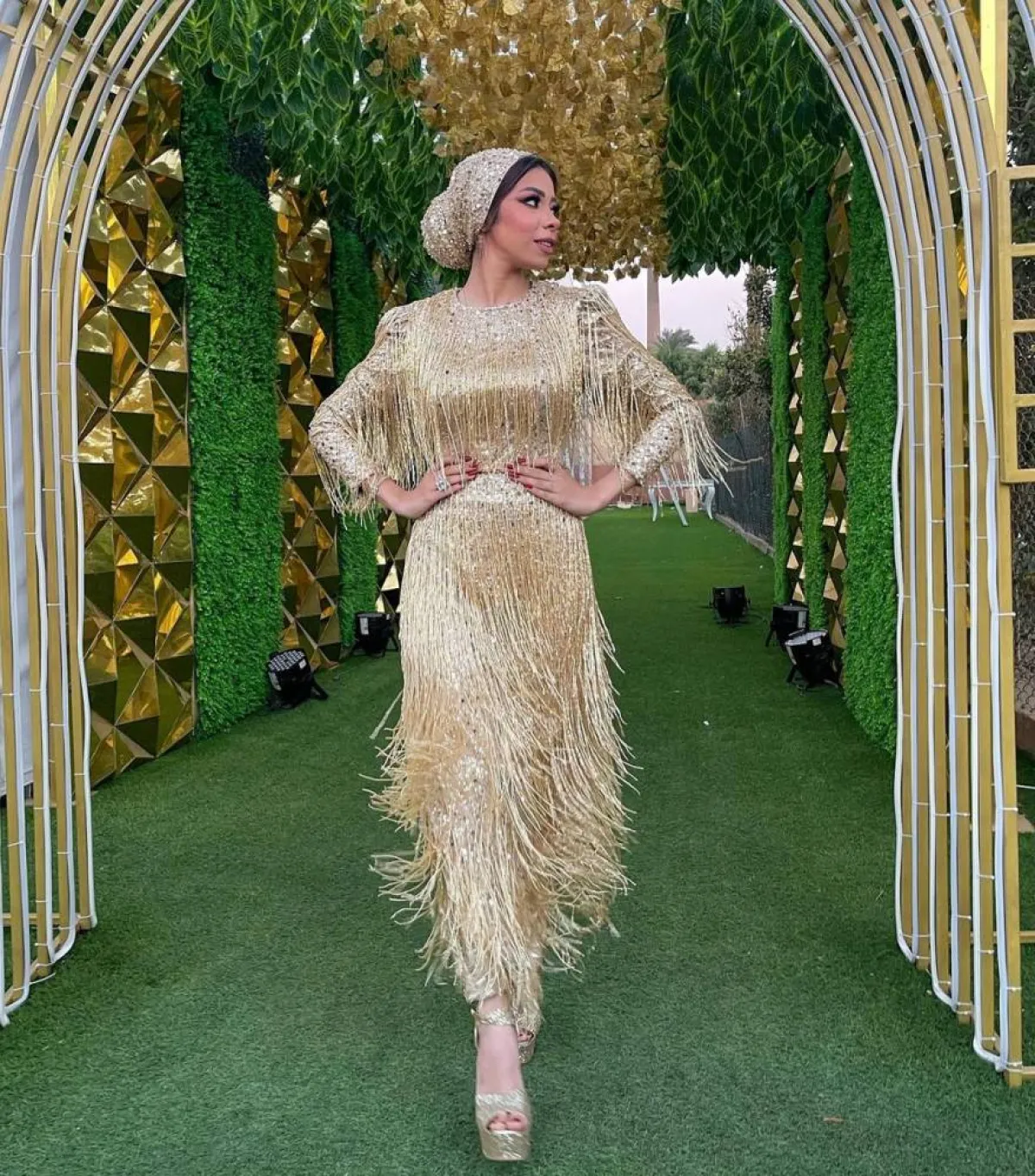 منة السني بفستان ميتاليك ذهبي مزين بالشراشيب