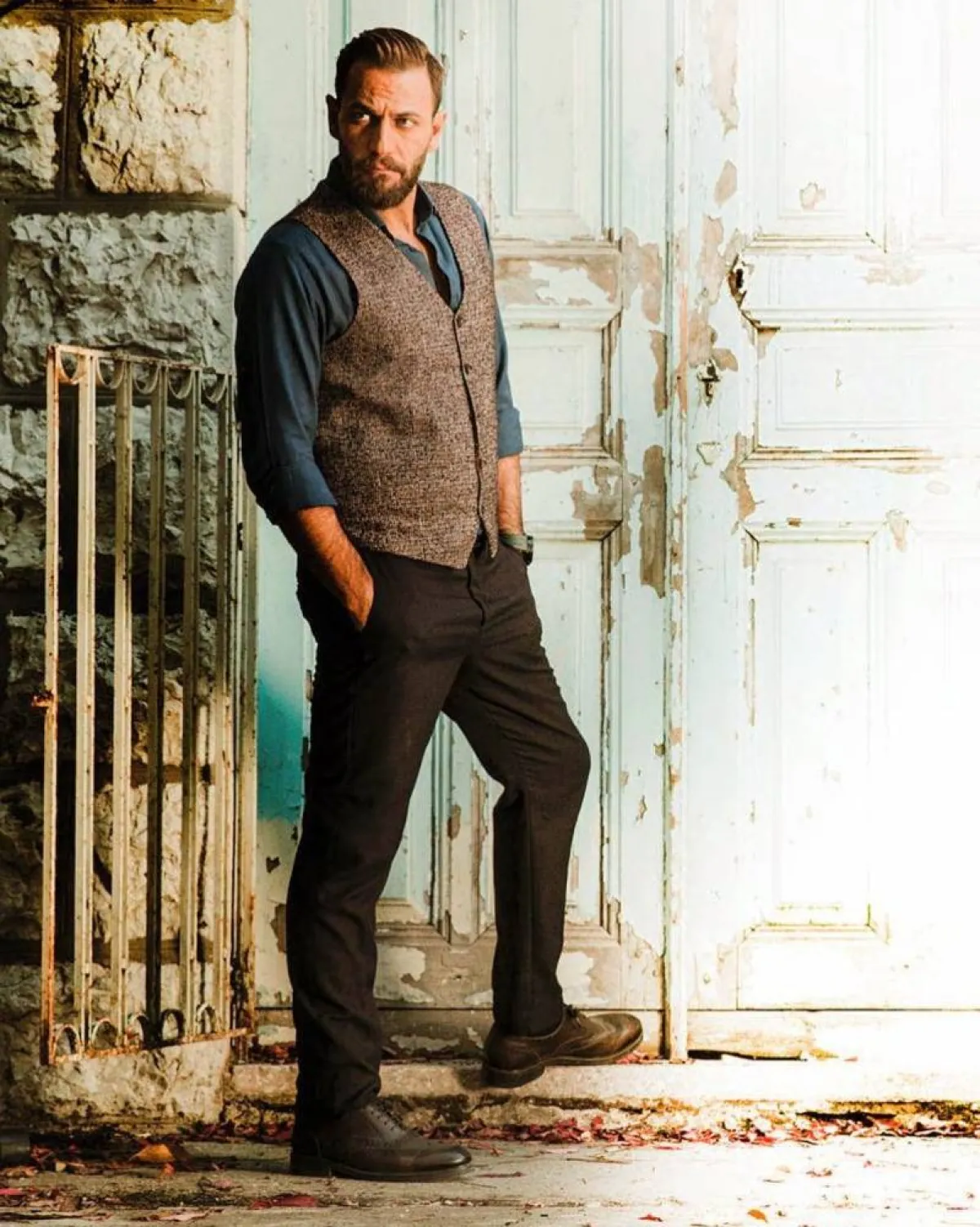 نيكولا معوض بفيست بني صوف مع قميص أزرق داكن وبنطلون بني 