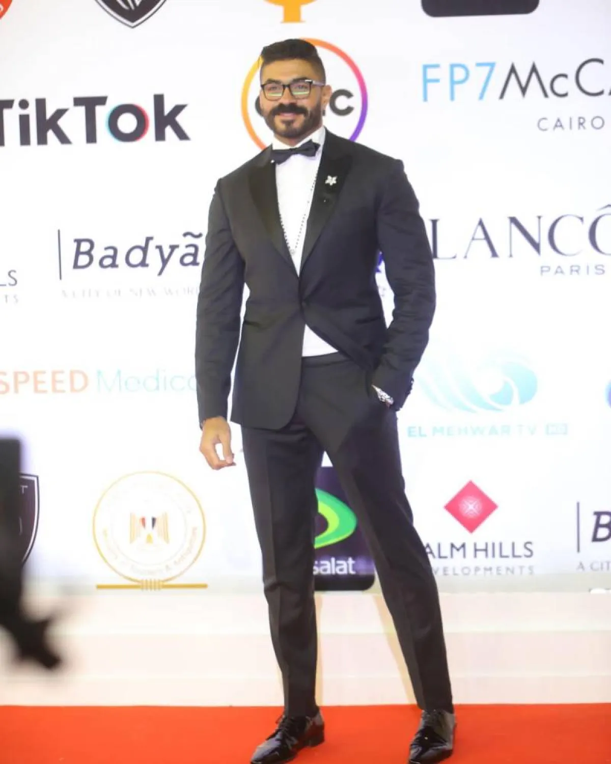 خالد سليم، ببدلة توكسيدو سوداء مع قميص أبيض وبابيون صغير