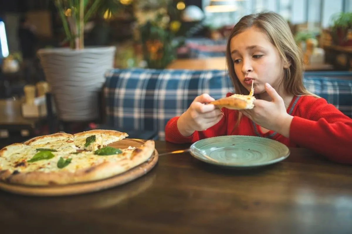 صورة لطفلة مصابة بأنيميا الفول تتناول طعاماً لا يحتوي على الفول