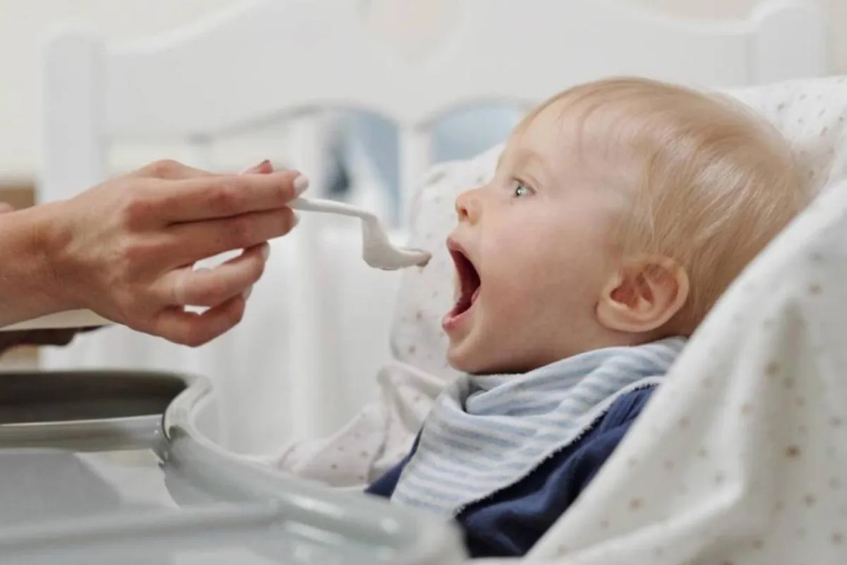 صورة لأم تحرص على تقديم الطعام بملعقة ليس بها بقايا الفول