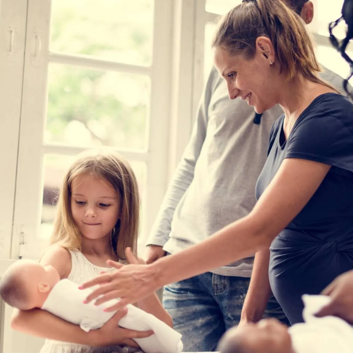 صورة لطفلة تتعلم حمل أخيها